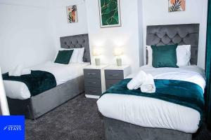 特伦特河畔斯托克2ndHomeStays-3 Bedroom House - Sleeps 6 - City Centre -Stoke-on-Trent的绿白色客房内的两张床