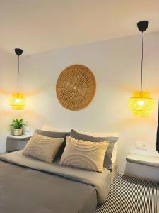 阿彻奇洛斯Aegean Serenity - Sea View Retreat的卧室配有一张带两盏灯的墙壁床。