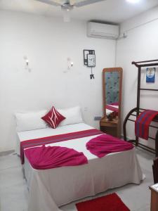 科伦坡WISH RESIDENCE SEASIDE Colombo3的一间卧室配有红色和白色床单
