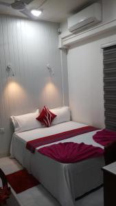 科伦坡WISH RESIDENCE SEASIDE Colombo3的卧室配有带红色枕头的大型白色床