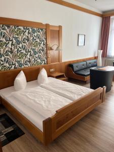 巴特维尔德巴德Hotel Sonne by Mastiff的一间卧室配有一张大床和一张沙发