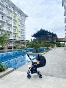 麦克坦119 Amani Grand Mactan Resort的婴儿在游泳池旁的婴儿车里