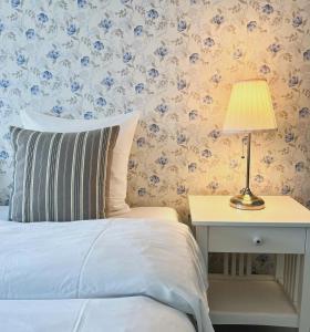 阿灵厄散库斯贝德酒店的一间卧室配有一张床和一张带台灯的桌子