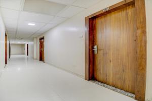 孟买OYO Hotel Address Inn的办公室大楼内一条空的走廊,有木门