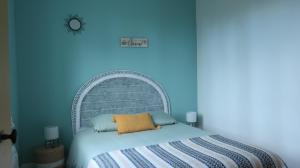 米米藏Côté lac的卧室配有白色床和蓝色墙壁