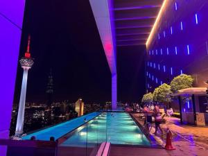 吉隆坡Platinum Sky Park Kuala Lumpur的享有夜间空间针景致的游泳池
