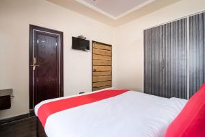 拉加蒙德里OYO Seera Enclave的一间卧室配有一张带红白毯子的床