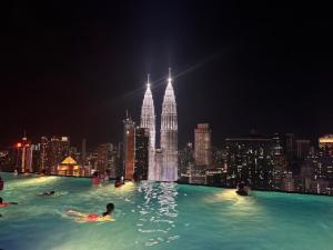 吉隆坡Platinum Sky Park Kuala Lumpur的一座游泳池,晚上在水里的人在城市里