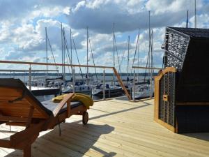 艾恩松Houseboat Hecht in Egernsund at the Marina Minde的船上的木制甲板上配有一张床