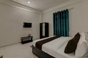 瓦拉纳西OYO Flagship Hotel Aanandwan Palace的酒店客房,配有床和电视