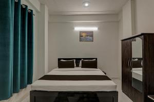 瓦拉纳西OYO Flagship Hotel Aanandwan Palace的一间卧室配有一张带绿色窗帘的大床