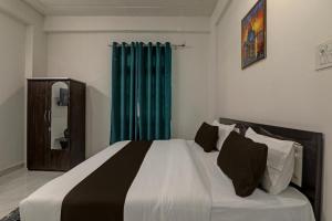 瓦拉纳西OYO Flagship Hotel Aanandwan Palace的一间卧室配有一张带蓝色窗帘的大床
