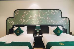 大叻Goldient Boutique Hotel的一间卧室设有两张带大床头板的床
