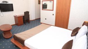 巴库Hotel & Bistro的酒店客房配有一张床、一张书桌和一台电视。