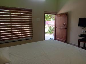 黎明之村CS GARDEN RESORT的一间卧室设有一张床和一个大窗户