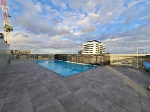 墨尔本Panoramic Views 2br With Pool And Free Carpark的建筑物屋顶上的游泳池