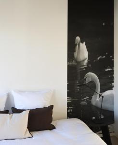 布鲁日Residence9Bruges的一间卧室配有一张床,水中有两个天鹅
