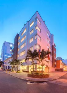 卡利Basic Hotel Centenario by Hoteles MS的一座棕榈树环绕的大建筑