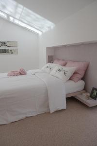 多博沃Villa Alma Vista的卧室配有白色床和粉红色枕头