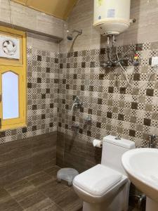 乌提Hotel Hill Valley, Ooty的浴室配有卫生间、盥洗盆和淋浴。