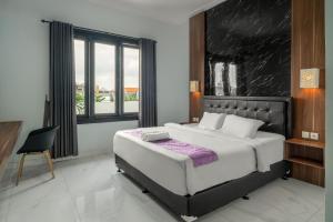 登巴萨巴厘梦幻科斯特尔酒店的一间卧室配有一张大床和一把椅子