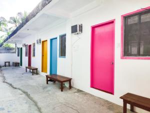 巴顿港Garpeza Backpackers的楼里一排有长椅的色彩鲜艳的门