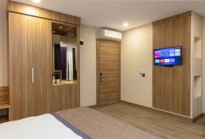 安塔利亚Ema Houses的一间酒店客房,配有一张床和一台墙上的电视