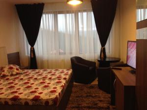 兰卡Pensiunea Roka的一间卧室设有一张床、一台电视和一个窗口。