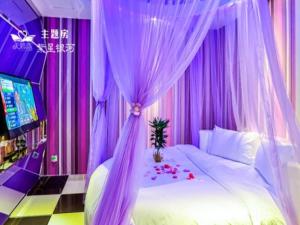 深圳Swan of Love Shenzhen Nanshan hotel的卧室配有带紫色窗帘的床