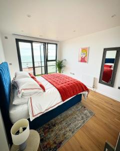 拉姆斯盖特Stunning Beach Front Apartment with Sea views, FREE Parking & Balcony的一间卧室配有一张带红色毯子的床