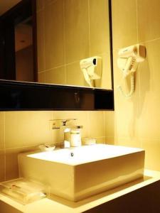 无锡JTOUR Inn Wuxi Railway Station Shangmadun Metro Station的浴室设有白色水槽和镜子