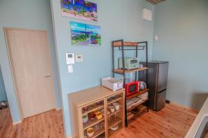 奄美Sawa Terrace - Vacation STAY 97941v的厨房配有冰箱和带微波炉的架子。