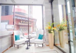 长春City Comfort Inn Changchun Chongqing Road Huolicheng的带两把椅子的房间和鲜花窗户