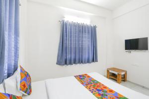 纳西克FabHotel Blue Ocean MNJ Resort的白色的客房配有床和电视。