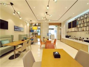 成都City Comfort Inn Chengdu Jinniu Wanda Liangjiaxiang Metro Station的餐厅内带桌椅的用餐室