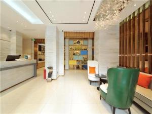 成都City Comfort Inn Chengdu Jinniu Wanda Liangjiaxiang Metro Station的大堂设有绿椅和前台