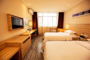 郑州City Comfort Inn Zhengzhou Lvcheng Square Metro Station的酒店客房设有两张床和一台平面电视。