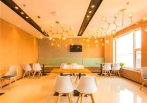 长春JTOUR Inn Qingnian Road Zhubang Plaza Yanming Lake的一间带桌椅和吊灯的用餐室