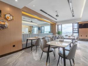 昆明Gya Hotel Kunming Zijin Center Xiaodongcun Metro Station的餐厅设有桌椅和窗户。