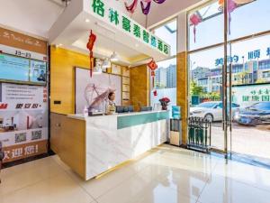 昆明GreenTree Inn Express Kunming East Passenger Station Huazhicheng的一家快餐店,有一位女士站在柜台上