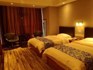 ZhuanwachangSuper 8 Hotel Changchun Jingyue Xincheng Street Bashu Yingxiang的酒店客房带两张床和一张桌子以及椅子。