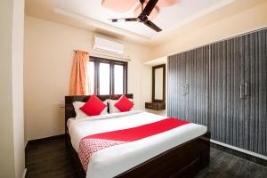 拉加蒙德里OYO Seera Enclave的一间卧室配有一张带红色枕头的大床