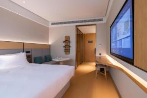 上海Ji Hotel Shanghai Yangpu Gym的酒店客房设有一张床和一台大电视