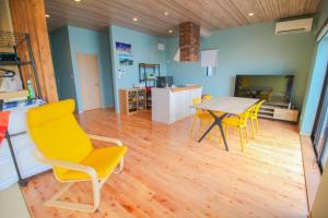 奄美Repos Terrace - Vacation STAY 97966v的一间带桌子和黄色椅子的用餐室