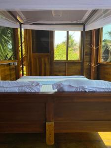 阿鲁甘湾Surf Beach Hotel的一张大床,位于带两个窗户的房间