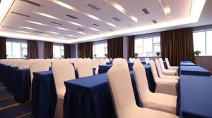 郑州Starway Hotel Zhengzhou Jingguang Road Metro Station的一间会议室,配有白色的椅子和蓝色的桌子