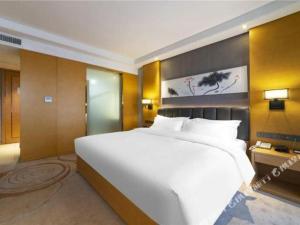 济南Borrman Hotel Jinan Yijia Exhibition Center Laotun Metro Station的一张大白色的床,位于酒店客房内