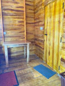 阿鲁甘湾Surf Beach Hotel的木板房,设有长凳和门