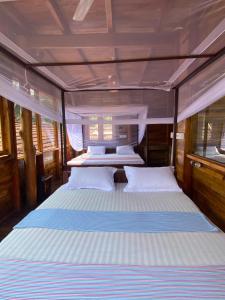 阿鲁甘湾Surf Beach Hotel的船上一间卧室配有两张床