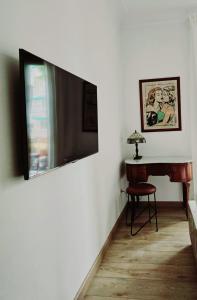 马略卡岛帕尔马Jaime III - Palma center - Luxury Suites的一间墙上配有电视的房间,配有桌子